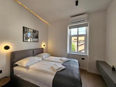a bedroom with a large bed with a window at Elegant Teo Apartment TourAs in Ljubljana Old Town in Ljubljana
