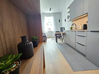 a kitchen with white cabinets and a vase on the floor at Elegant Teo Apartment TourAs in Ljubljana Old Town in Ljubljana