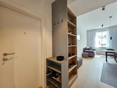 a room with a door and a living room with a couch at Elegant Teo Apartment TourAs in Ljubljana Old Town in Ljubljana