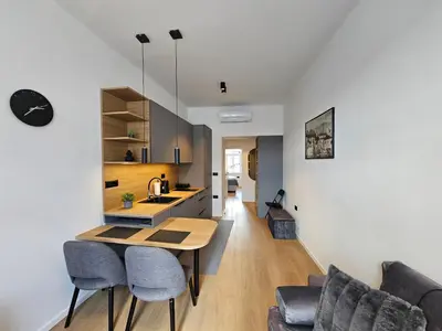 a kitchen and living room with a table and chairs at Elegant Teo Apartment TourAs in Ljubljana Old Town in Ljubljana