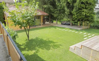 a backyard with a lawn with a wooden fence at Mali Raj in Mengeš