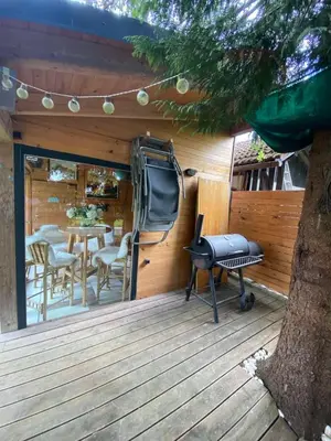 a deck with a grill and a table and chairs at Mali Raj in Mengeš
