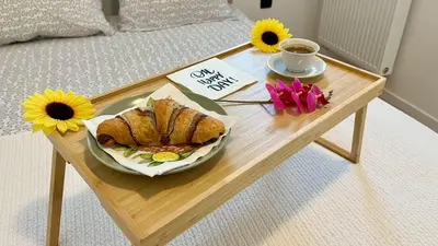 a table with a plate of bread and flowers on a bed at Mali Raj in Mengeš