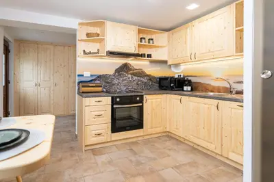 a kitchen with wooden cabinets and a stove at Studio Barbara in Bohinj
