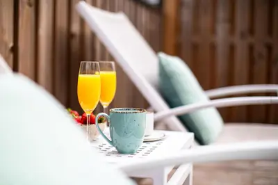 two glasses of orange juice and a cup on a table at Apartma 21 - Ajda in Bovec