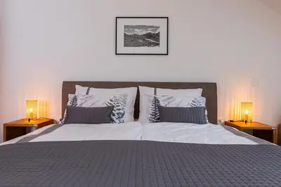 a bedroom with a large bed with two lamps at Apartma 21 - Ajda in Bovec