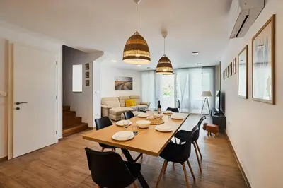 a dining room and living room with a table and chairs at VIPAVA river house in Vipava
