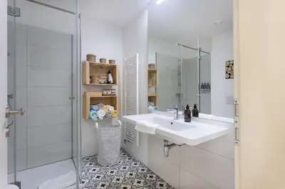 a white bathroom with a sink and a mirror at Spacious Apartment in Historic Centre & FREE Parking in Ljubljana