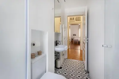 a white bathroom with a toilet and a sink at Spacious Apartment in Historic Centre & FREE Parking in Ljubljana
