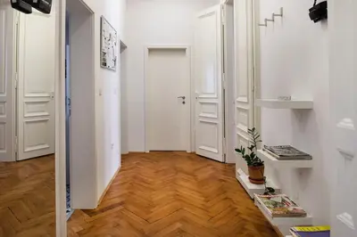 a hallway with white doors and a wooden floor at Spacious Apartment in Historic Centre & FREE Parking in Ljubljana