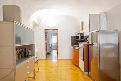 a kitchen with stainless steel appliances and wooden floors at Artistic Studio Quiet Crusader Street Apartment in Ljubljana
