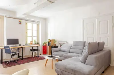 a living room with a couch and a desk with a computer at Artistic Studio Quiet Crusader Street Apartment in Ljubljana
