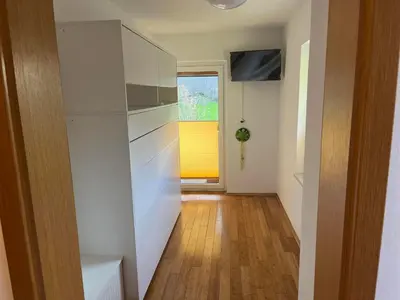a hallway with white cabinets and a window at Sončni zahod in Kobarid