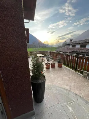 a patio with potted plants and a fence at Sončni zahod in Kobarid