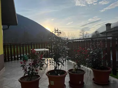 three potted plants on a balcony with a table at Sončni zahod in Kobarid