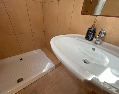 a bathroom with a white sink and a tub at SOS Apartments in Radovljica