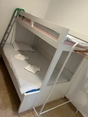 a white bunk bed with a ladder in a room at SOS Apartments in Radovljica
