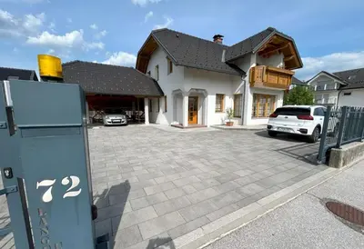 a house with a car parked in a driveway at SOS Apartments in Radovljica