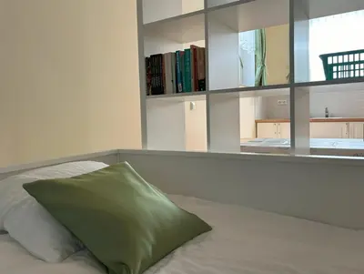 a bed with a green pillow on top of it at SOS Apartments in Radovljica