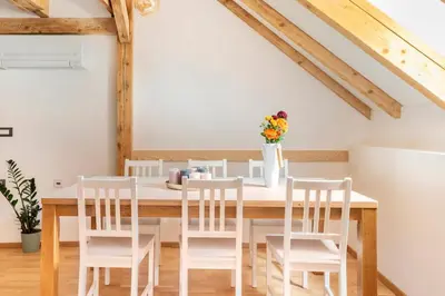 a dining room with a wooden table and white chairs at Sofija's Central Apartments in Ljubljana