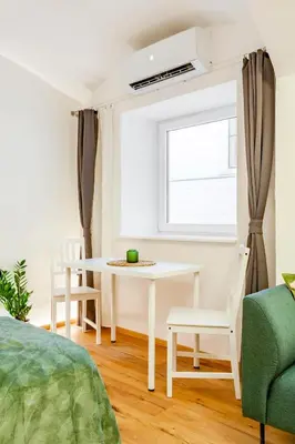 a white dining room with a table and chairs at Sofija's Central Apartments in Ljubljana
