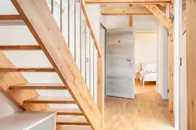 a wooden staircase in a room with a bedroom at Sofija's Central Apartments in Ljubljana