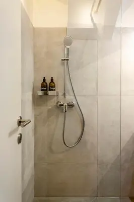 a shower with a shower head in a bathroom at Sofija's Central Apartments in Ljubljana