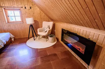 a room with a chair and a fireplace at Relax house AVUS with Sauna in Slappe dʼIdria