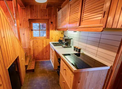 a kitchen with wooden cabinets and a counter top at Relax house AVUS with Sauna in Slappe dʼIdria