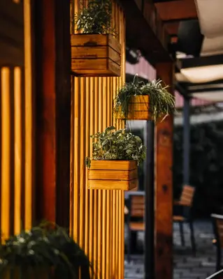 a group of potted plants in wooden boxes on a building at B&B Mio Nonno Rooms Ljubljana in Ljubljana