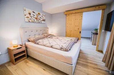 a bedroom with a bed and a wooden floor at B&B Mio Nonno Rooms Ljubljana in Ljubljana