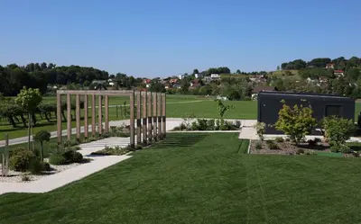 a garden with green grass and a wooden fence at Mobilna hiška Sončni Gaj in Ptuj