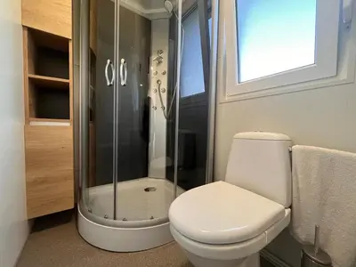 a bathroom with a toilet and a glass shower at Mobilna hiška Sončni Gaj in Ptuj