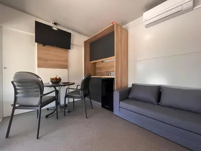 a room with a couch and a table and chairs at Mobilna hiška Sončni Gaj in Ptuj