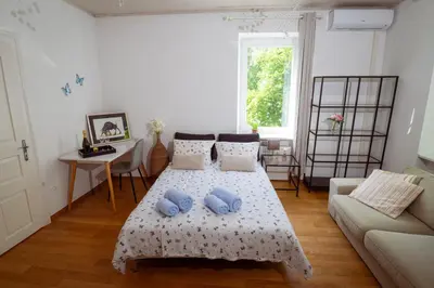 a living room with a bed and a couch at Riverview Residence - with parking in Ljubljana