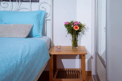 a vase of flowers on a table next to a bed at Riverview Residence - with parking in Ljubljana
