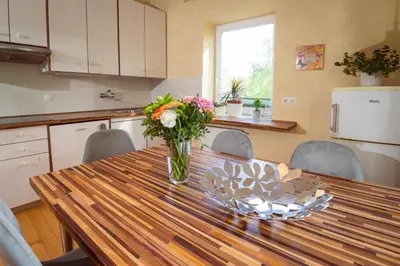 a vase of flowers on a wooden table in a kitchen at Riverview Residence - with parking in Ljubljana
