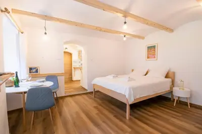 a bedroom with a bed and a table and chairs at Jerry's Old Town Garden in Ljubljana
