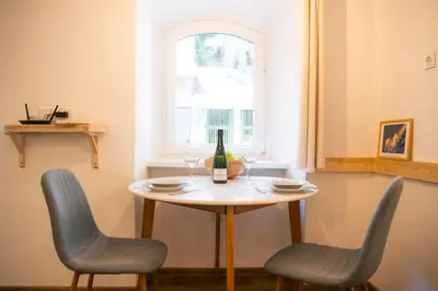 a table with two chairs and a bottle of wine at Jerry's Old Town Garden in Ljubljana
