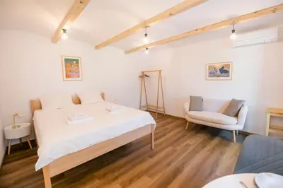 a bedroom with a large bed and a chair at Jerry's Old Town Garden in Ljubljana