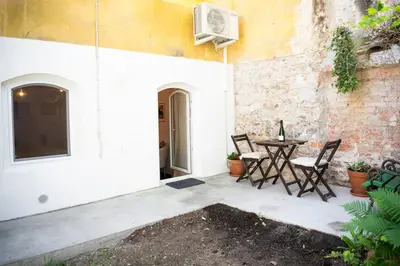 a patio with a table and chairs next to a building at Jerry's Old Town Garden in Ljubljana