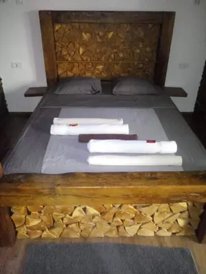 a bed with a wooden head board with towels on it at Haloze ForMe in Zavrč