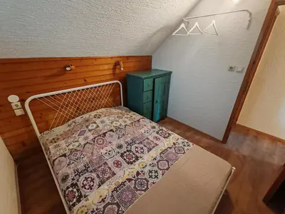 a bedroom with a bed and a green cabinet at Apartment Ursa Major in Preddvor