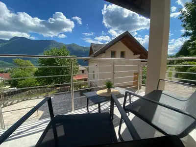 a balcony with a table and chairs and mountains at Apartmaji Sofija&Ana in Bovec