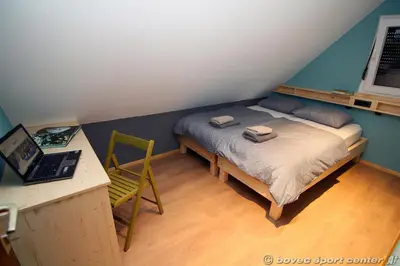 a bedroom with a bed and a desk with a laptop at Glamping Virje in Bovec