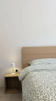 a bedroom with a bed and a night stand with a lamp at Nono Apartment in Renče