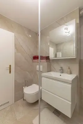 a bathroom with a sink and a toilet and a mirror at DSE Apartment in Celje
