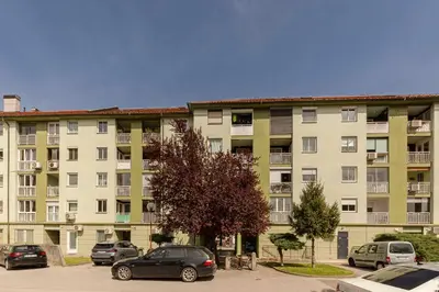 a large apartment building with cars parked in a parking lot at DSE Apartment in Celje