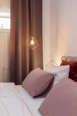 a bedroom with two beds and a light fixture at DSE Apartment in Celje