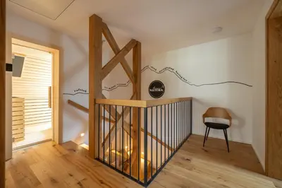 a hallway with a wooden door and a chair at House Natura Savica in Bohinj